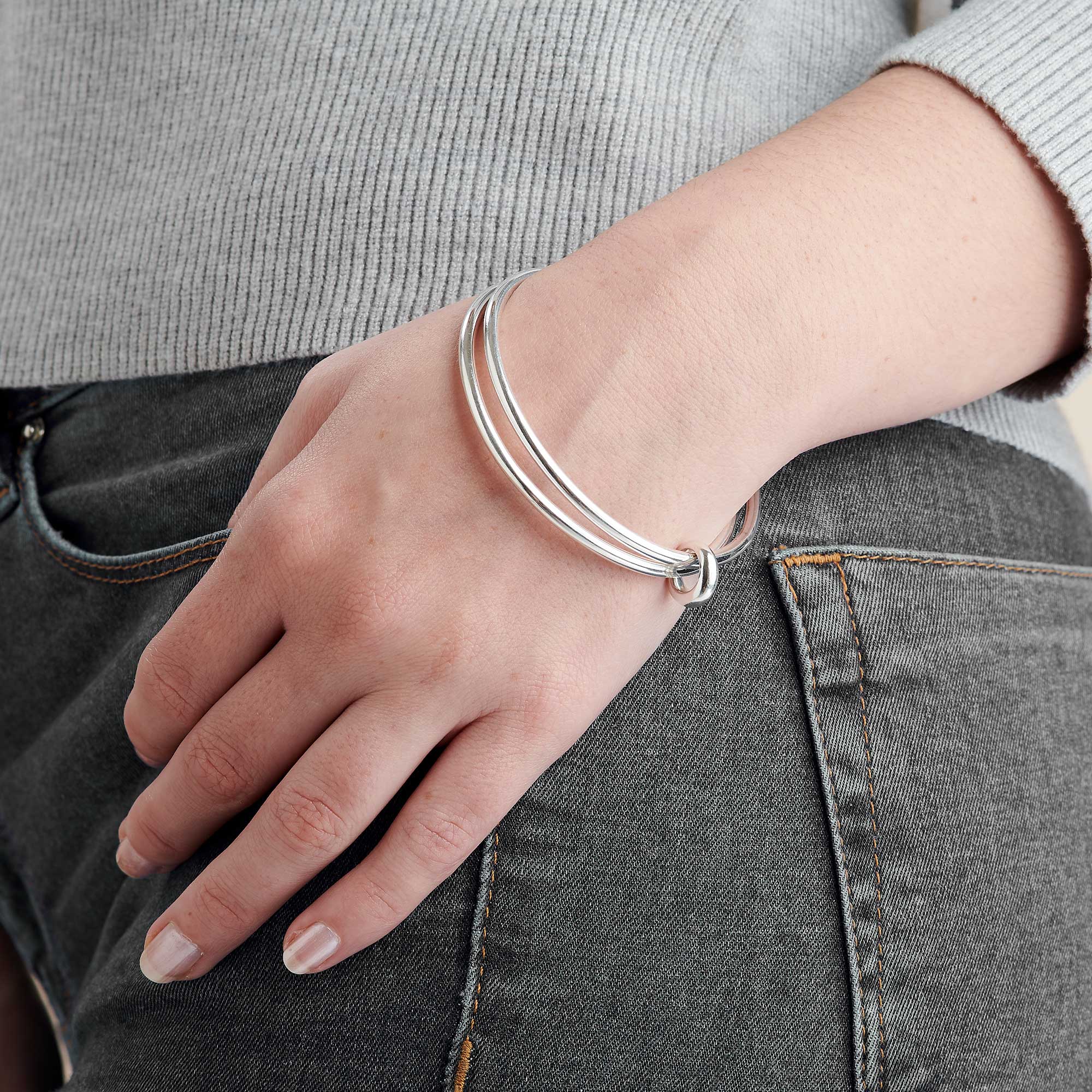 Two solid silver bangles joined in eternity by an asymmetrical Eclipse loop - a gorgeous designer made bangle for women.
